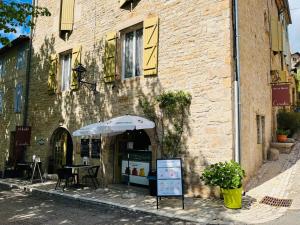 een tafel met een paraplu buiten een gebouw bij Sweet Home Cornelia in Bruniquel
