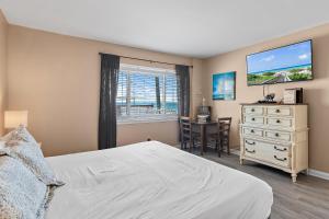 ein Schlafzimmer mit einem Bett und eine Kommode mit einem Fenster in der Unterkunft Capri by the Gulf 108 - Beachy Keen Bungalow in Destin
