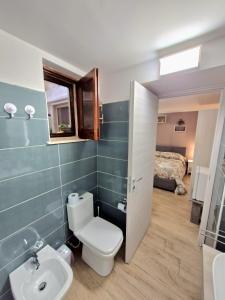 a bathroom with a toilet and a sink and a bed at Medea in Syracuse +44 photos