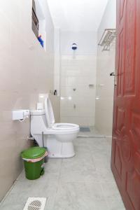 La salle de bains est pourvue de toilettes et d'une poubelle verte. dans l'établissement Jay Homes - Rehema Apartments, à Naivasha