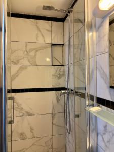 a bathroom with a shower with a glass door at Hôtel Des Fontaines in Paris +25 photos