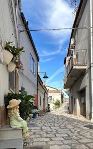 an alley with a statue sitting on a bench at Filera in Garaguso +9 photos