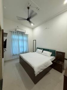 a bedroom with a bed and a ceiling fan at Shree shyam pay at hotel in Khātu +4 photos