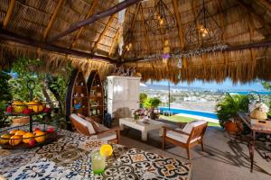 a room with a table and chairs and a pool at Villa Bella Bed & Breakfast Inn in Cruz de Huanacaxtle