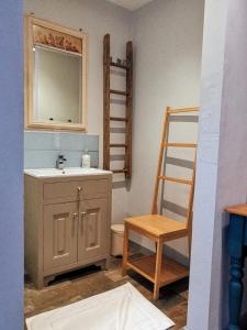 a bathroom with a sink and a wooden chair at the Nook, Romantic cottage for two, Dartmoor and SW coast in Bovey Tracey
