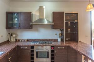 een keuken met houten kasten en een kookplaat met oven bij Villa Dahlia in Marrakesh