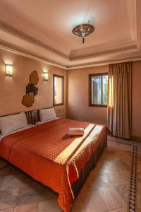 een slaapkamer met een groot bed met een rode sprei bij Villa Dahlia in Marrakesh +25 foto's
