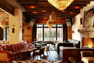 a living room with leather couches and a fireplace at The Ludlow Hotel in New York