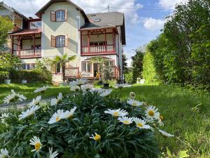 a house with a flower garden in front of it at Villa Bella Vita in Seeboden