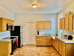 a kitchen with wooden cabinets and a sink and a refrigerator at LG Lofts -1 bedroom unit in Kiel close to Road America Elkhart Lake in Kiel
