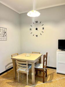 a dining room table with a clock on the wall at Mary's Home Cogoleto in Cogoleto
