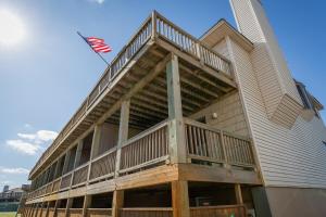 an apartment building with a balcony with an american flag at The Sandy Edge - OBX in Kitty Hawk