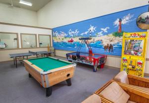 a recreation room with a pool table and a mural at The Sandy Edge - OBX in Kitty Hawk