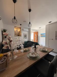 einen Esstisch mit Tellern und Blumen darauf in der Unterkunft Apartment Batinica in Šibenik