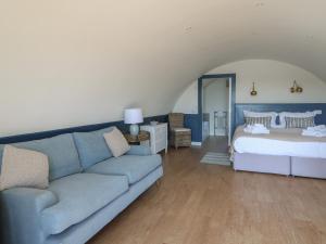 een woonkamer met een blauwe bank en een bed bij Torsa in Oban