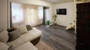 a living room with a couch and a flat screen tv at Szilvia Vendéghàz in Szarvas