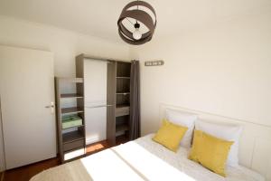 a bedroom with a bed with yellow pillows at Appartement et terrasse Port du Pouliguen in Le Pouliguen +7 photos