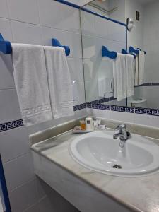 a bathroom with a sink and a mirror and towels at Hotel Playa Bocaina in Mojácar +41 photos