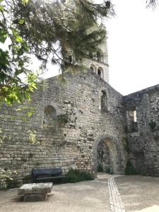 a brick building with a bench in front of it at La Figuiere du village in Lavilledieu
