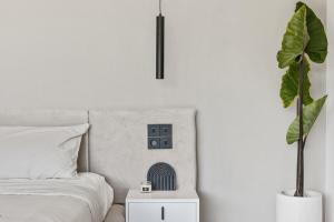 a bedroom with a bed and a nightstand with a plant at Villa Luxfield - Peaceful minimalist 2BR villa with Big garden and Views in Cemagi +28 photos