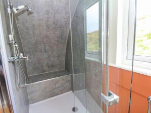 een douche met een glazen deur in een badkamer bij Fladda in Oban