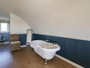 een badkamer met een wit bad en een blauwe muur bij Scarba in Oban