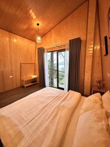 a bedroom with a large bed with a large window at Đảo Ngọc Bungalow in Vĩnh Phúc