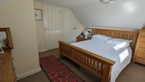 una camera da letto con un letto grande e uno specchio di Rose Cottage a Ledbury