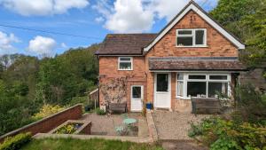 una casa in mattoni con porte bianche e un cortile di Rose Cottage a Ledbury