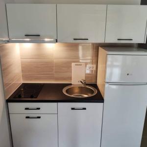 a small kitchen with a sink and a refrigerator at Vi studio city center 2min to sea in Bar