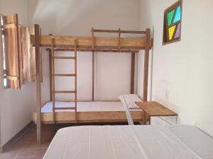 a bedroom with a bunk bed and a desk at Quarto para 4 a 900 metros da Vila do Capão ll in Vale do Capao