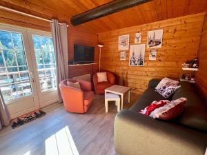 a living room with a couch and a chair and a tv at Le cocon de La Bresse in La Bresse