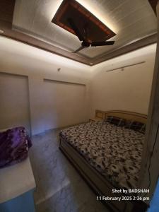 a bedroom with a bed and a ceiling with a tv at Kazzakpura koniya road in Varanasi