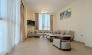 a living room with a couch and a table at Saray Deluxe Hotel Apartments in Abu Dhabi