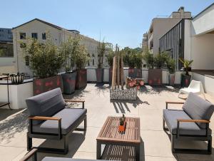 a patio with two chairs and a table on a building at Le Penthouse de Boulogne in Boulogne-Billancourt +6 photos