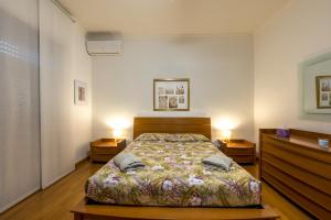 a bedroom with a bed and two night stands at Alice's Apartment in Civitavecchia
