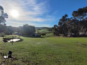 a park with a bench in a grass field at Kleinwatervalplaas Farm Stay Accomodation in Caledon