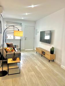 a living room with a couch and a flat screen tv at La Perla del Pinatar in San Pedro del Pinatar