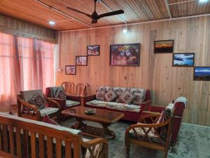 a living room with a couch and chairs and a table at Sai Saraswati Homestay in Kalimpong
