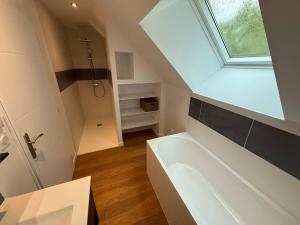 un bagno con una grande vasca bianca e una finestra di Chambre Coulans-sur-Gée a Coulans-sur-Gée