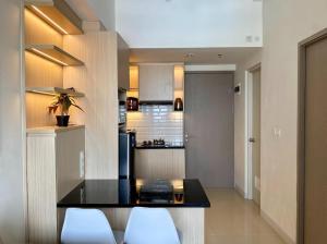 a kitchen with a table and two white chairs at Vasanta Innopark 1BR with Sky View by Damaresa in Jarakasta