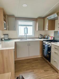 eine Küche mit Spüle und Herd in der Unterkunft Burano Nook - Tattershall Lakes in Tattershall