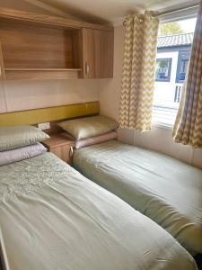 zwei Betten in einem kleinen Zimmer mit Fenster in der Unterkunft Burano Nook - Tattershall Lakes in Tattershall + 8 Fotos