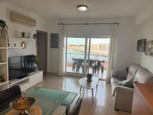 ガンディアにあるMagnifico Piso en Playa de Gandiaのソファとガラスのテーブルのあるリビングルーム