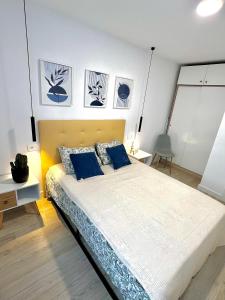 a bedroom with a large bed with blue pillows at La Perla del Pinatar in San Pedro del Pinatar