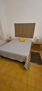 ein Schlafzimmer mit einem Bett mit einem gelben Kissen darauf in der Unterkunft Casa de playa, rodeada de monte, campo y mar in La Coronilla