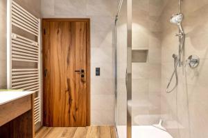 Un baño con ducha y puerta de madera. en Wieshof, en Laion 18 fotos más
