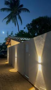 a white building with lights on the side of it at Pousada Nova Era in Galinhos
