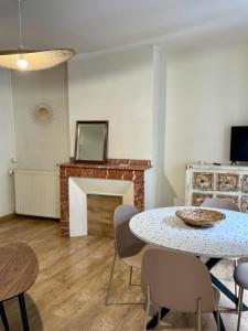 un salon avec une table et des chaises et une cheminée dans l'établissement Le cocon coloré - Appartement centre ville, à Lourdes