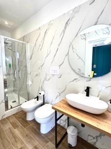 a bathroom with two toilets and a sink and a mirror at Charm Airport in Reggio di Calabria +41 photos